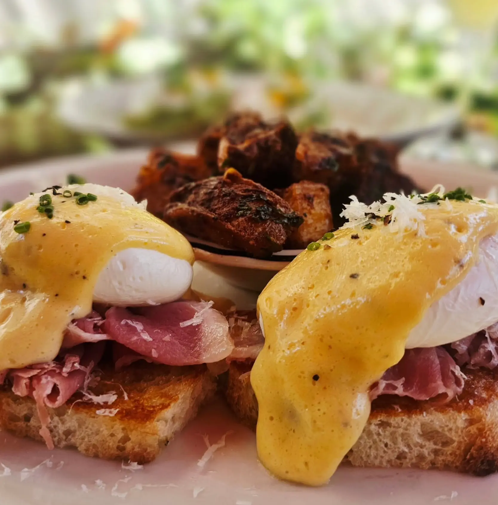 Eggs Benedict with cured ham and breakfast potatoes.