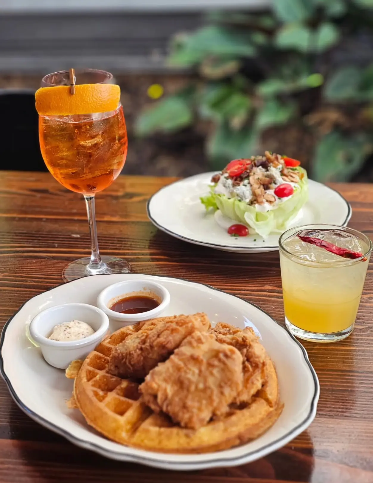 Chicken and waffles with salad and two cocktails.
